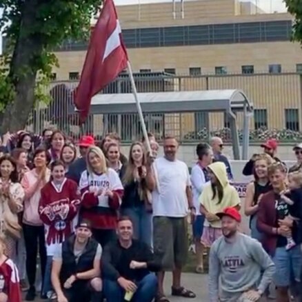 Hokeja līdzjutēji pie ASV vēstniecības Rīgā bildējas un noliek ziedus