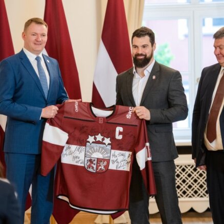 Foto: Latvijas hokejisti pēc vēsturiskas uzvaras piemēra uzvalkus un dodas uz Saeimu