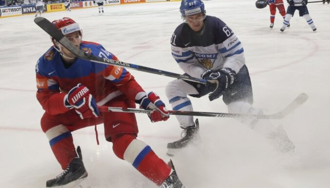 Alexei Yemelin of Russia in action with Aleksander Barkov of Finland