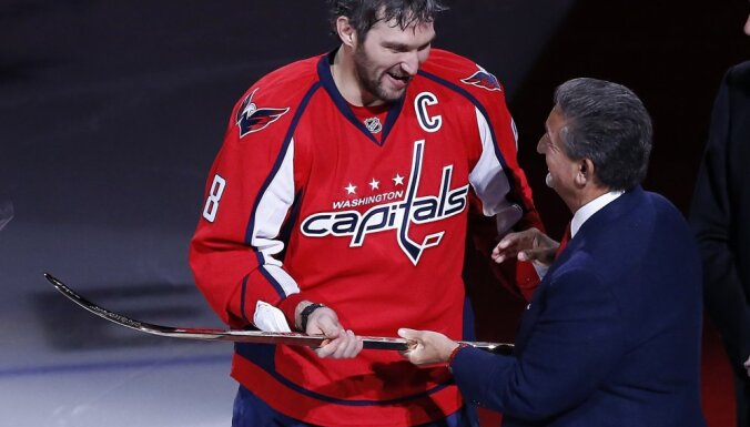 Washington Capitals owner Ted Elonsis gives a gold stick to Alex Ovechkin