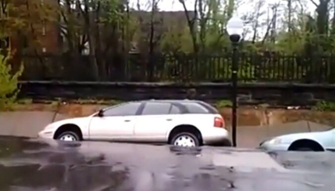 Video: ASV pēc spēcīgām lietavām zeme 'aprij' automašīnas