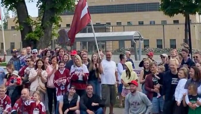 Hokeja līdzjutēji pie ASV vēstniecības Rīgā bildējas un noliek ziedus